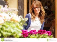 mature photos smiling mature woman florist small business flower shop owner shallow focus royalty free stock using telephone laptop take orders store